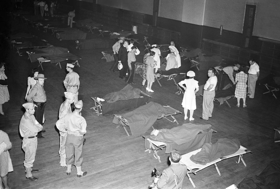 FILE - This July 6, 1944 file photo shows a scene at the armory where bodies were brought in the aftermath of a fatal circus fire in Hartford. Conn. Authorities are exhuming the bodies of two victims of the 1944 circus fire in hopes of identifying a Vermont woman who has been missing since then. The exhumations began Monday morning, Oct. 7, 2019, at the Northwood Cemetery in Windsor, Conn. Officials will analyze DNA samples to determine whether one of the buried women is Grace Fifield of Newport, Vt. (AP Photo/Murray Becker, File)