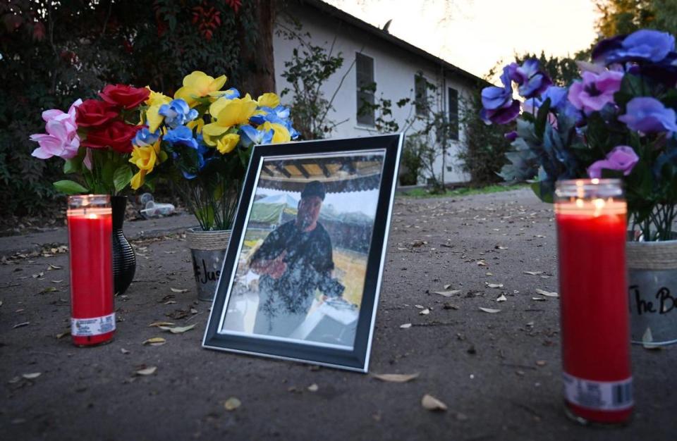 Una foto de Frank Bond se ve en un camino de entrada cerca de donde se encontró su cuerpo, mientras la comunidad se reunía para una vigilia con velas, el viernes 12 de enero de 2024 por la noche, en Reedley.