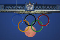 The full moon rises through the Olympic Rings hanging beneath Tower Bridge during the London 2012 Olympic Games August 3, 2012. REUTERS/Luke MacGregor (BRITAIN - Tags: SPORT OLYMPICS ENVIRONMENT CITYSPACE)