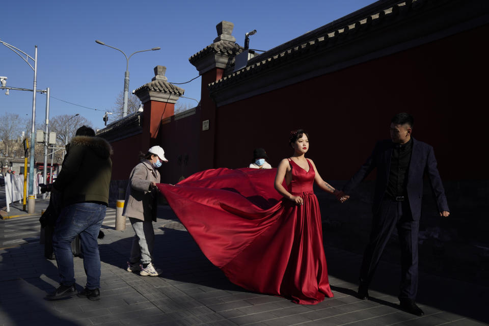 A couple has their wedding photos taken near the Forbidden City area in Beijing on Sunday, Dec. 20, 2020. Lovebirds in China are embracing a sense of normalcy as the COVID pandemic appears to be under control in the country where it was first detected. (AP Photo/Ng Han Guan)