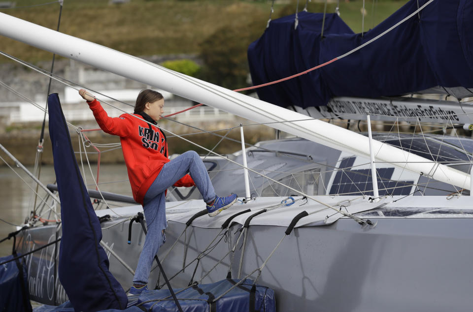 Greta Thunberg climbs onto the boat Malizia as it is moored in Plymouth, England Tuesday, Aug. 13, 2019. Greta Thunberg, the 16-year-old climate change activist who has inspired student protests around the world, is heading to the United States this week - in a sailboat. (AP Photo/Kirsty Wigglesworth)