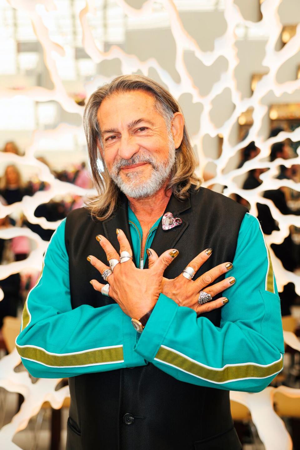 A man, with his hands on his chest, poses for a photo.