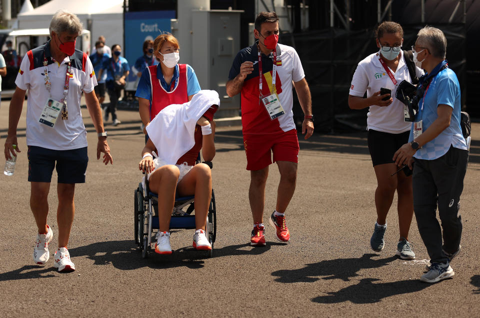 TOKYO, JAPAN - JULY 28: Paula Badosa of Team Spain is helped away from the court in a wheelchair after having to retire from her Women's Singles Quarterfinal match against Marketa Vondrousova of Team Czech Republic on day five of the Tokyo 2020 Olympic Games at Ariake Tennis Park on July 28, 2021 in Tokyo, Japan. (Photo by David Ramos/Getty Images)