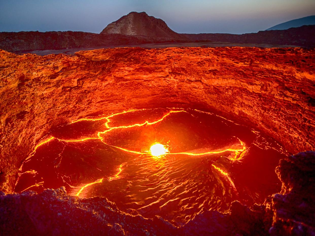 View from the crater rim of Erta Ale - one of the most active vulancoes in the world - into the active, red glowing lava lake. Erta Ale is a continuously active basaltic shield volcano in the Afar Region of northeastern Ethiopia, only some kilometers from