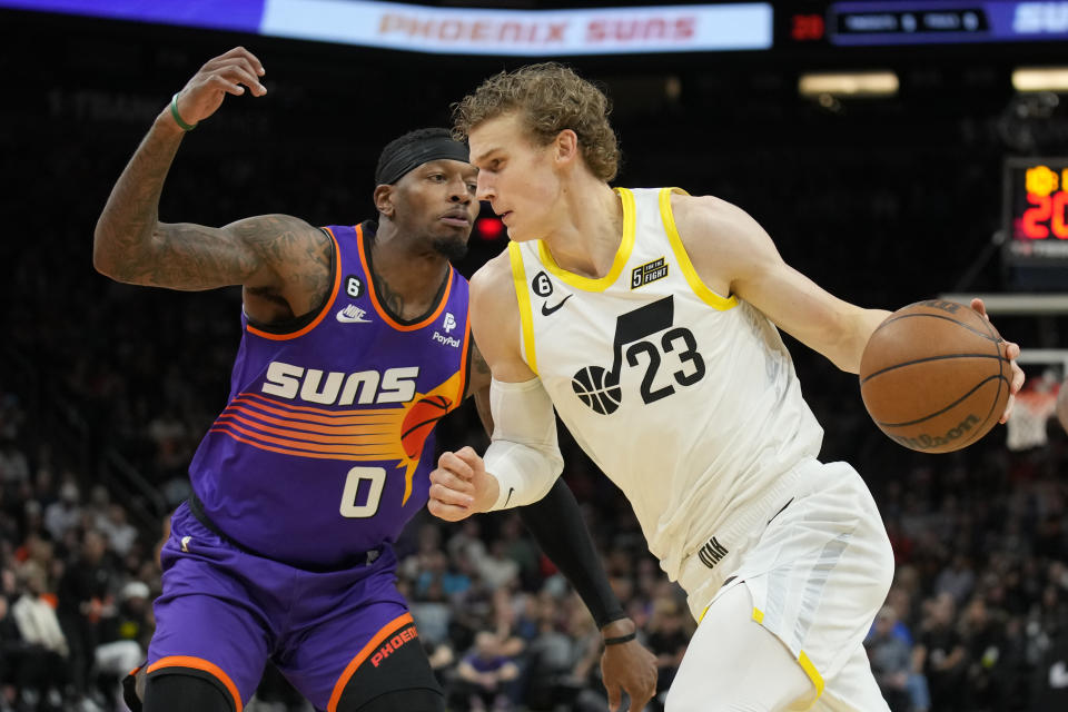 Utah Jazz forward Lauri Markkanen (23) drives past Phoenix Suns forward Torrey Craig during the first half of an NBA basketball game, Saturday, Nov. 26, 2022, in Phoenix. (AP Photo/Rick Scuteri)