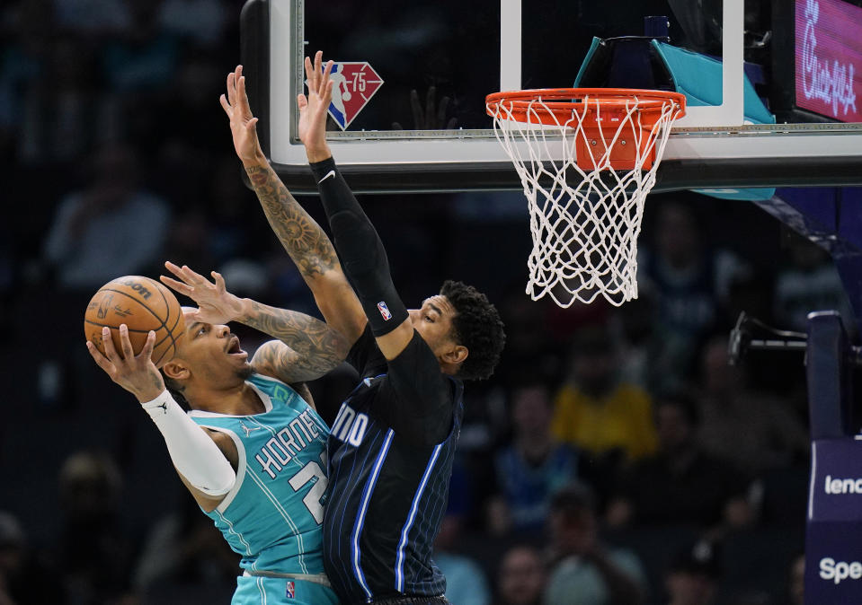 Charlotte Hornets forward P.J. Washington, left, drives to the basket against Orlando Magic forward Chuma Okeke, right, during the first half of an NBA basketball game on Thursday, April 7, 2022, in Charlotte, N.C. (AP Photo/Rusty Jones)