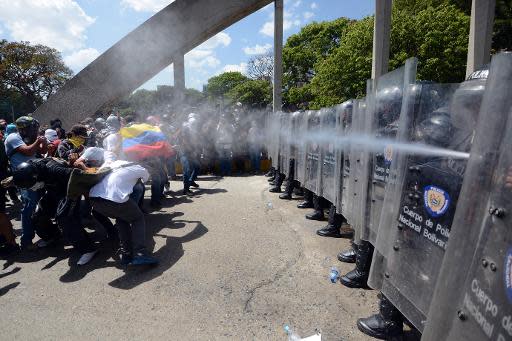 Unos manifestantes en contra del Gobierno venezolano se enfrentan a la Policía antidisturbios en Caracas, el 20 de marzo de 2014 (AFP/Archivos | Juan Barreto)