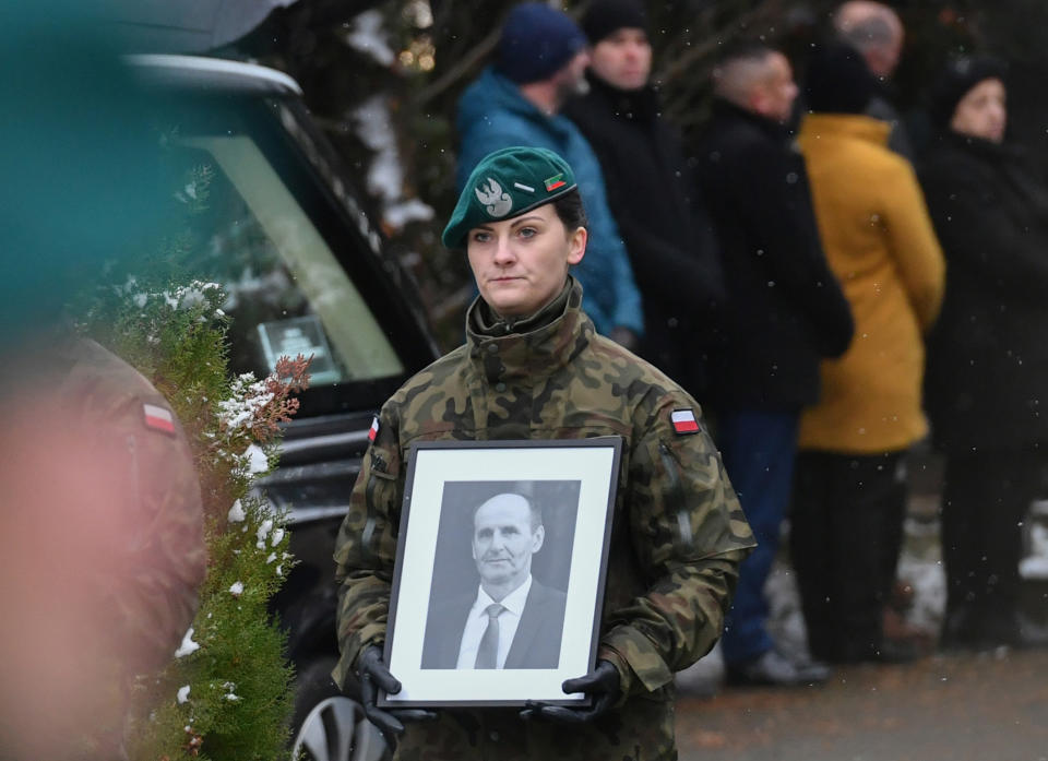 A Polish Border Guard official carries a photograph of Boguslaw Wos, one of two Polish men killed in a missile explosion, ahead of his funeral, in Przewodow, Poland, Saturday, Nov. 19, 2022. A funeral for Wos was held on Saturday. Western officials said the deaths appeared to have been caused by a Ukrainian air defense missile that went astray as the country was defending itself against a barrage of Russian missiles directed at Ukraine’s power infrastructure. (AP Photo)