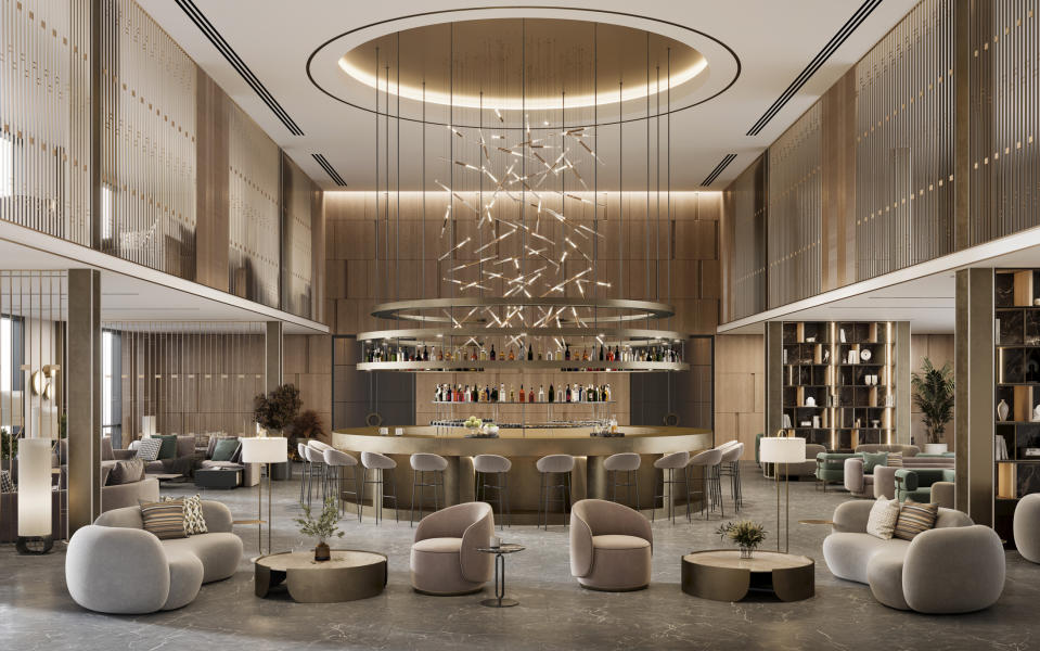 Elegant hotel lobby with a bar area, various seating arrangements, and a large chandelier