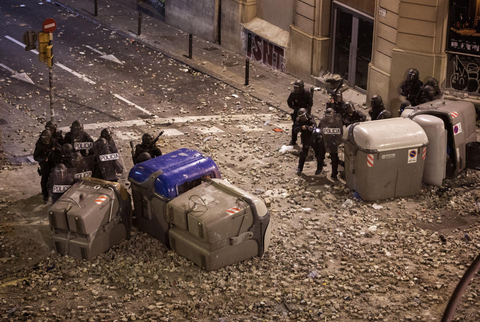 National police officers shoot rubber bullets to protesters, during clashes in Barcelona, Spain, Friday, Oct. 18, 2019.The Catalan regional capital is bracing for a fifth day of protests over the conviction of a dozen Catalan independence leaders. Five marches of tens of thousands from inland towns are converging in Barcelona's center for a mass protest. (AP Photo/Emilio Morenatti)