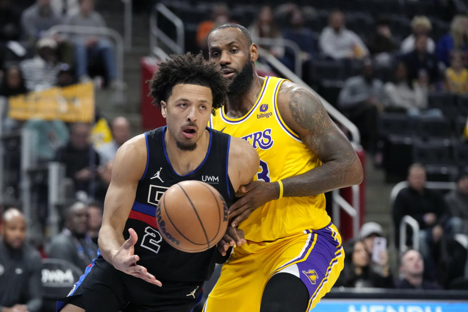 Detroit Pistons guard Cade Cunningham (2) passes the ball as Los Angeles Lakers forward LeBron James defends during the first half of an NBA basketball game, Wednesday, Nov. 29, 2023, in Detroit. (AP Photo/Carlos Osorio)