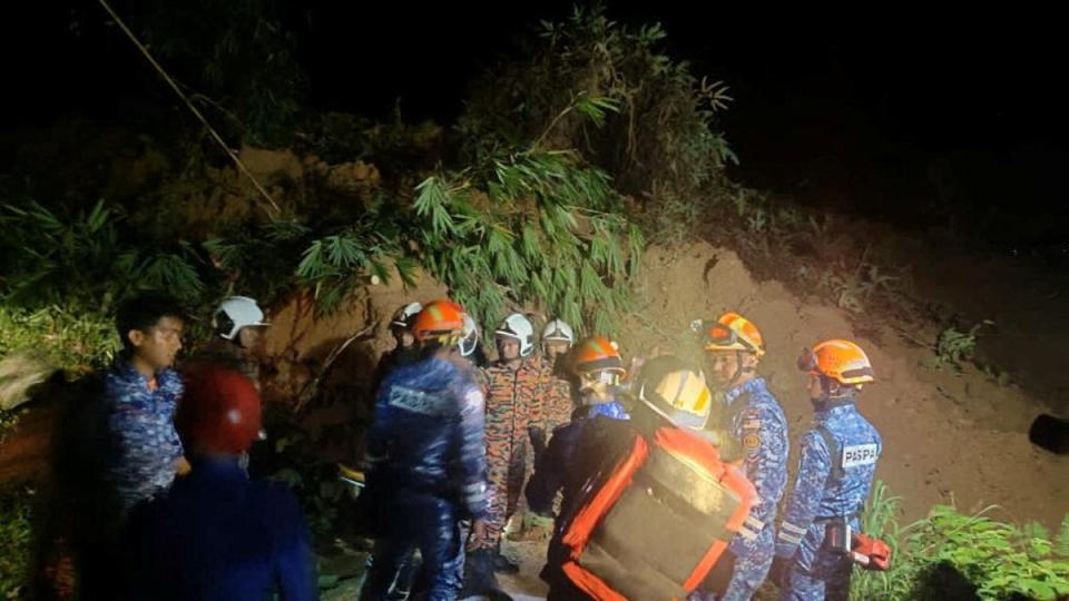 Rescuers work during a rescue and evacuation operation following a landslide at a campsite in Batang Kali, Selangor (via REUTERS)