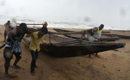 People move a boat to a safer place along the shore after the cyclone Titli at Gopalpur, in Ganjam district, in Odisha, India October 11, 2018. REUTERS/Stringer