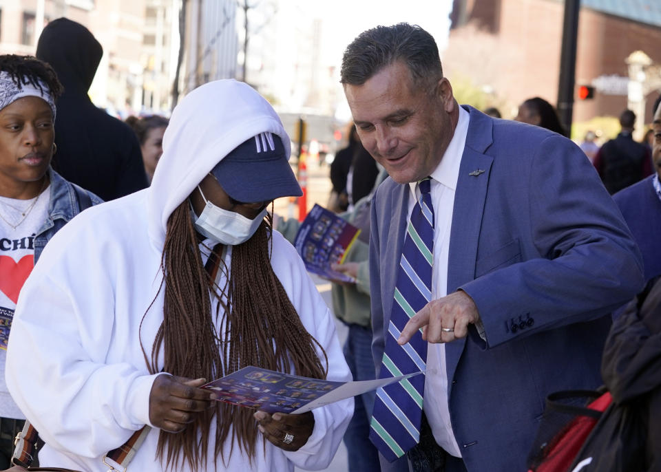 Democrat Thomas McDermott, right, a candidate for U.S. Senate, talks with voters outside of the City-County Building, Monday, Nov. 7, 2022, in Indianapolis. (AP Photo/Darron Cummings)