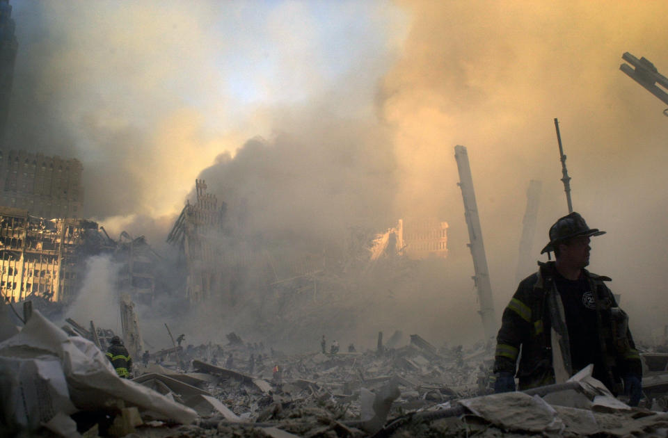 <p>A firefighter moves through piles of debris at the site of the World Trade Center in New York, Tuesday, Sept. 11, 2001. (AP Photo/Graham Morrison)</p> 