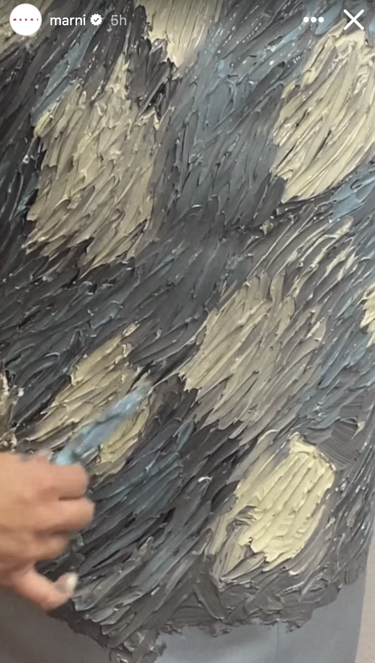 Close-up of textured art with hand partially visible, creating detailed strokes on canvas