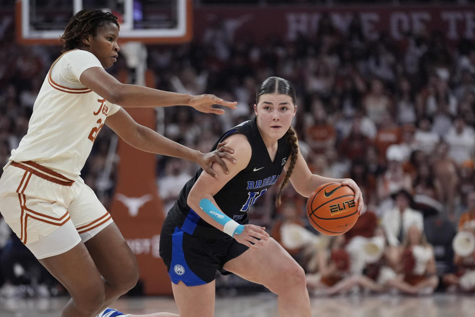 BYU guard Kailey Woolston, right, drives around Texas forward Khadija Faye, left, during the first half of an NCAA college basketball game in Austin, Texas, Saturday, March 2, 2024. (AP Photo/Eric Gay)