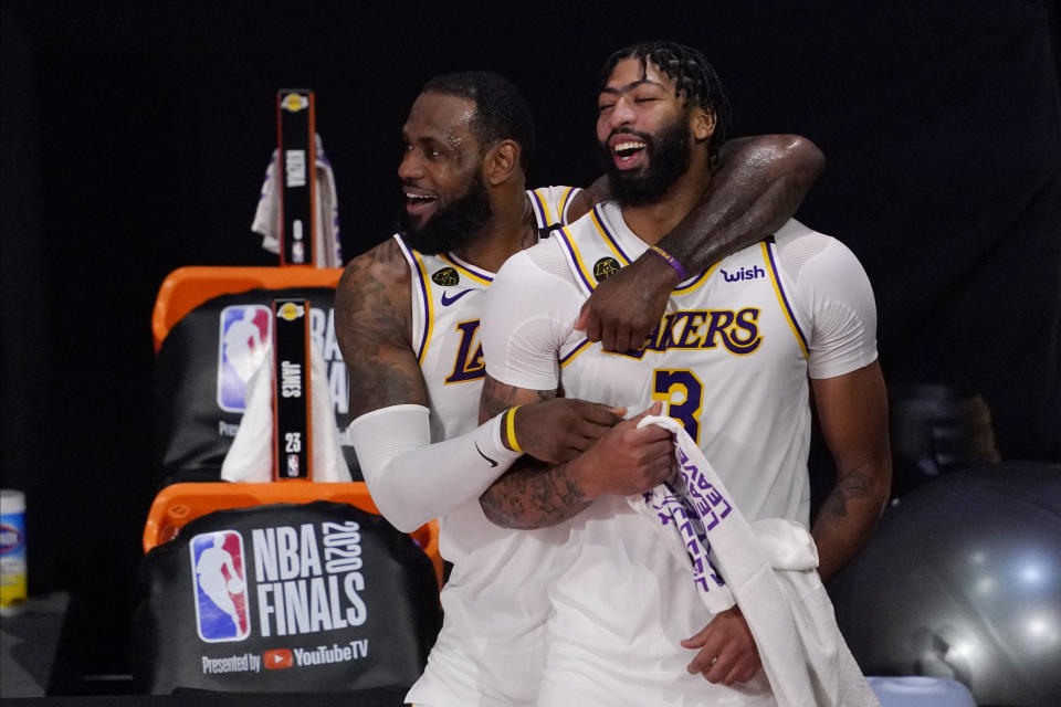 Los Angeles Lakers' LeBron James (23) and Anthony Davis (3) celebrate after the Lakers defeated the Miami Heat 103-88 in Game 6 of basketball's NBA Finals Sunday, Oct. 11, 2020, in Lake Buena Vista, Fla. (AP Photo/Mark J. Terrill)