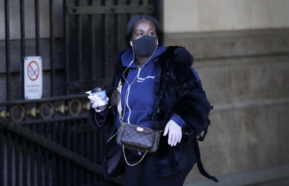 A woman wears a mask and gloves as she leaves a station in London, Monday, March 16, 2020. For most people, the new coronavirus causes only mild or moderate symptoms, such as fever and cough. For some, especially older adults and people with existing health problems, it can cause more severe illness, including pneumonia. (AP Photo/Kirsty Wigglesworth)