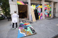 A passerby photographs a ransacked Coach store in the SoHo neighbourhood of New York, Monday, June 1, 2020. Protesters broke into the store Sunday night in reaction to George Floyd's death while in police custody on May 25 in Minneapolis. (AP Photo/Mark Lennihan)