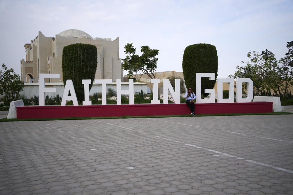 People sit outside the Catholic Church, Our Lady of the Rosary, at the Religious complex, in Doha, Qatar, Friday, Dec. 9, 2022. (AP Photo/Thanassis Stavrakis)