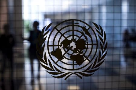 A United Nations logo is seen on a glass door in the Assembly Building at the United Nations headquarters in New York City September 18, 2015. REUTERS/Mike Segar/Files