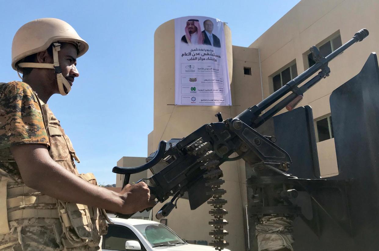 A soldier mans a machine gun on a patrol truck in front of a poster of Saudi's King Salman outside a hospital renovated by Saudi Arabia in Aden: Reuters