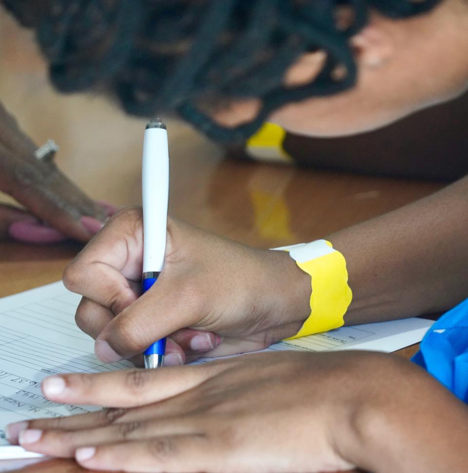 A Hurricane Dorian evacuee fills out paperwork at an emergency shelter in Nassau, Bahamas.