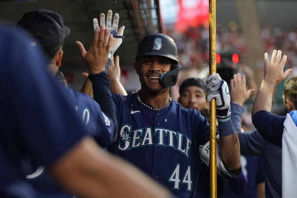 Seattle Mariners' Julio Rodriguez (44) celebrates in the dugout after hitting a home run during the fourth inning of a baseball game against the Los Angeles Angels in Anaheim, Calif., Friday, Aug. 4, 2023. J.P. Crawford also scored. (AP Photo/Ashley Landis)