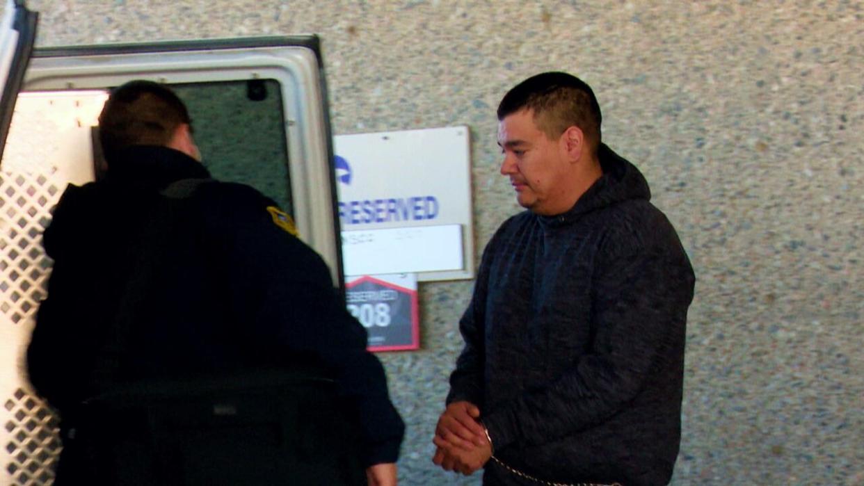 James Colosimo of Hay River, N.W.T., climbs into a vehicle while wearing handcuffs. Colosimo was sentenced this week to life in prison with no parole eligibility for 13 years for killing Meg Kruger in 2020. (Carla Ulrich/CBC - image credit)