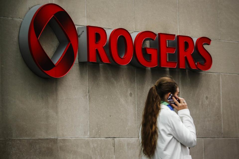 A woman speaks on her cell phone in front of a Rogers Communications Inc sign before the company’s annual general meeting for shareholders in Toronto April 22, 2014. (Reuters)