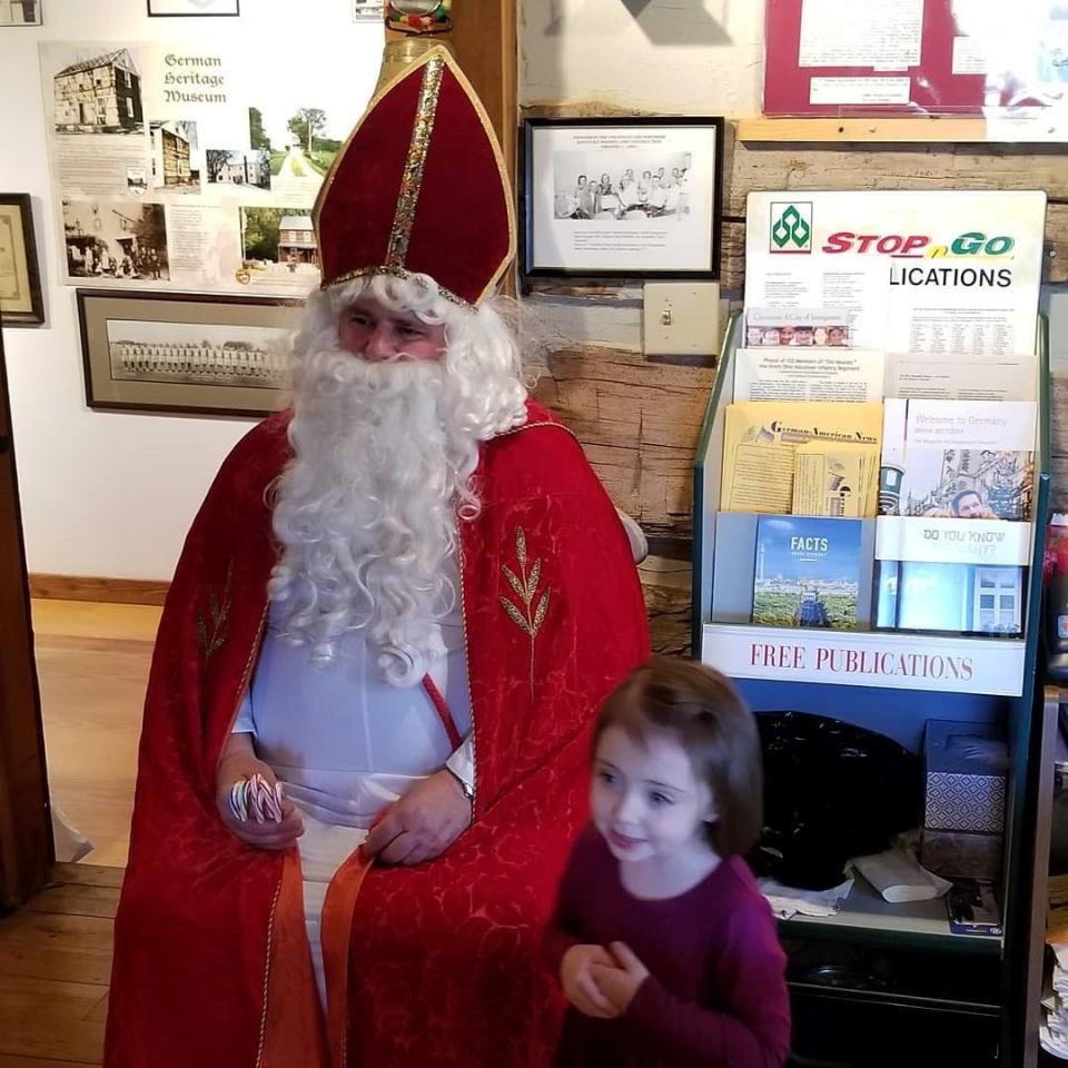 St. Nicholas distributing candy canes to children at a St. Nick's Day celebration at Cincinnati's German Heritage Museum.