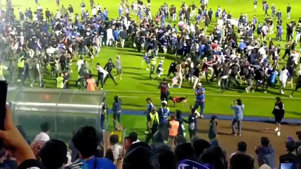 Fans invade the football pitch after a match between Arema FC and Persebaya Surabaya at Kanjuruhan Stadium, Malang, Indonesia (REUTERS)