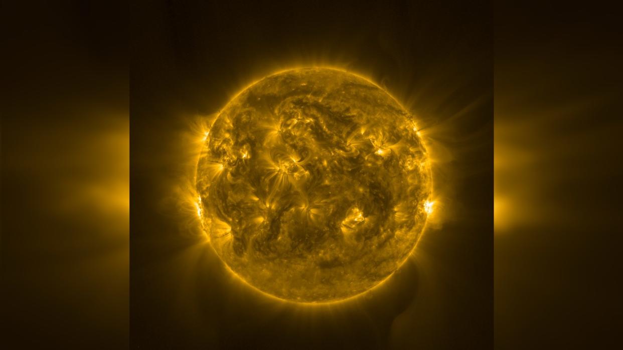  A photograph of the sun showing swirling formations of fire on its surface. 