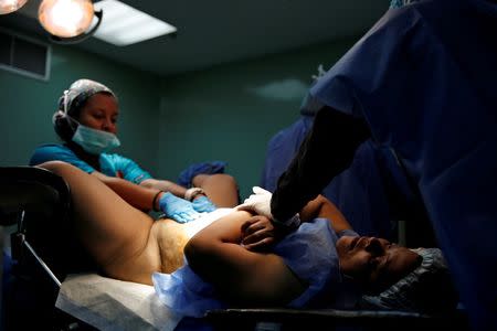 A patient lies on a bed during her sterilization surgery in the operating room of a hospital in Caracas, Venezuela July 27, 2016. REUTERS/Carlos Garcia Rawlins