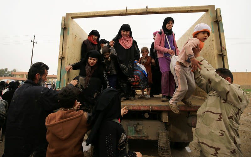 Displaced Iraqi people who fled their homes during a battle between Iraqi forces and Islamic State militants, arrive at a checkpoint to be transfer to Hammam al-Alil camp, in Mosul, Iraq, March 20, 2017. REUTERS/Thaier Al-Sudani