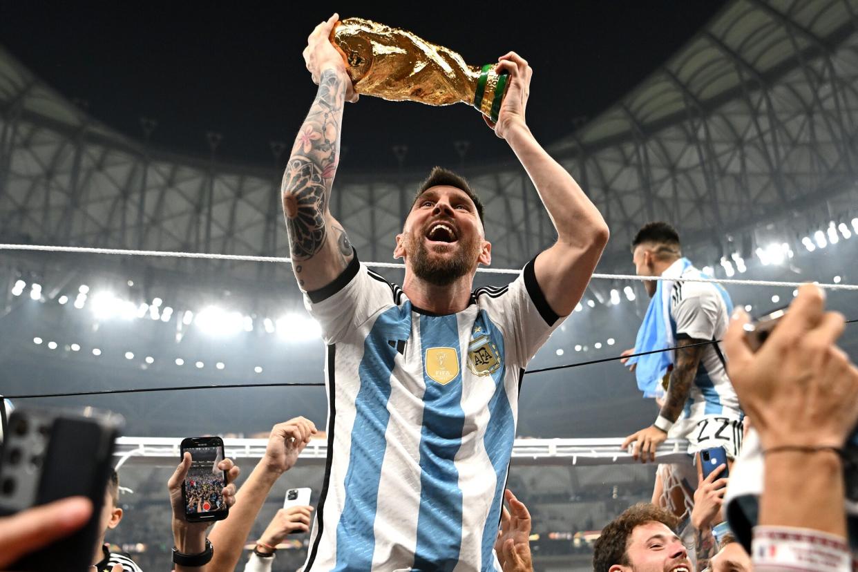 Lionel Messi of Argentina celebrates with the World Cup Trophy after winning the FIFA World Cup Qatar 2022 Final match between Argentina and France at Lusail Stadium on December 18, 2022 in Lusail City, Qatar.