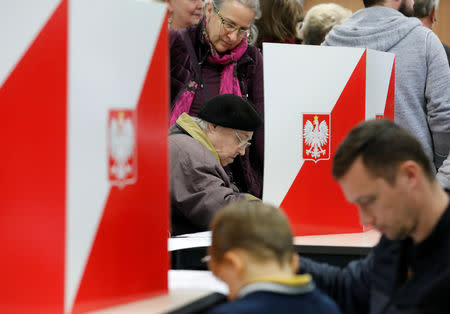 People attend the Polish regional elections, at a polling station in Warsaw, Poland, October 21, 2018. REUTERS/Kacper Pempel