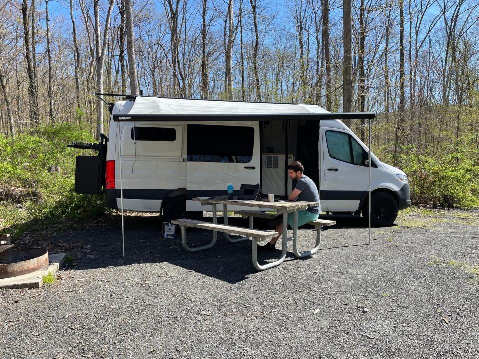 Austin working on a bench outside the sprinter van