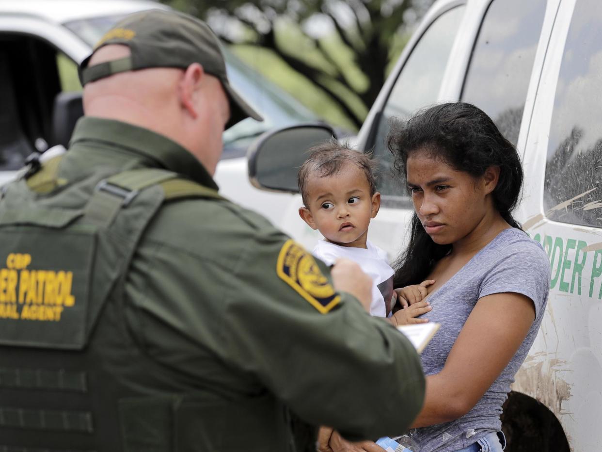 A mother migrating from Honduras holds her 1-year-old child as surrendering to U.S. Border Patrol agents after illegally crossing the border, near McAllen, Texas (AP)