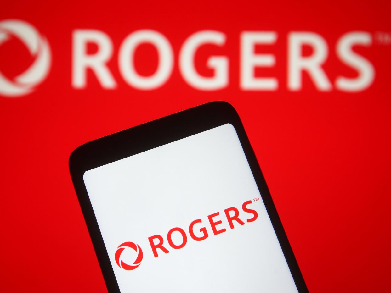 In this photo illustration, Rogers Communications logo of a Canadian media and telecommunications company is seen displaying, on a smartphone and a pc screen.