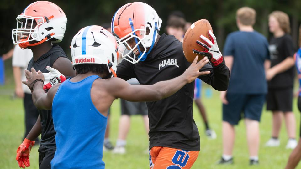 Millville's Lotzeir Brooks, center, reacts with teammates after Brooks made a one-handed catch during Millville High School's first football practice of the season held at Millville High School on Monday, August 7, 2023.  