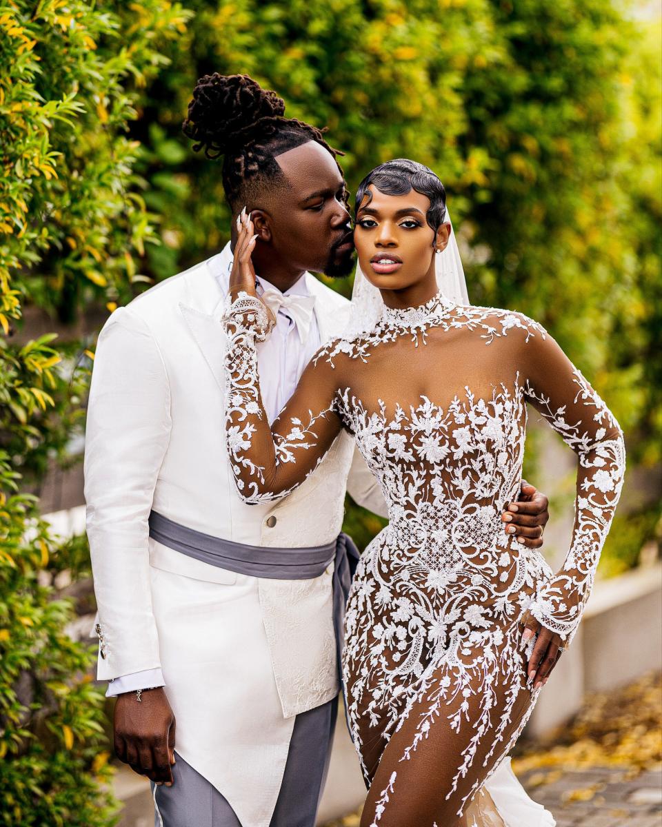 A groom kisses his bride on the cheek on their wedding day.