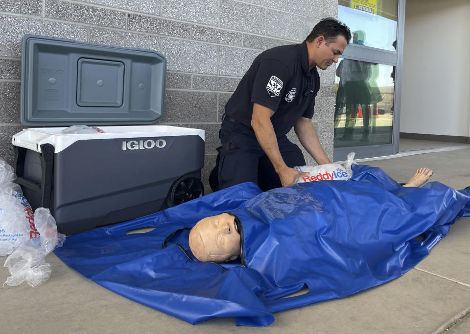 Phoenix Fire Capt. John Prato demonstrates a new protocol that the fire department in America’s hottest big city is adopting as the West braces for the first heat wave of the summer season, Monday, June 3, 2024, in Phoenix. The cold water immersion therapy already used by hospitals in the area will also now be used by Phoenix fire and paramedics personnel on every patient they encounter this season with signs of heat stroke. (AP Photo/Anita Snow)