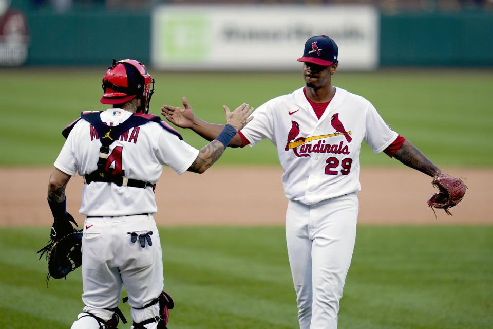 St. Louis Cardinals relief pitcher Alex Reyes (29) and catcher Yadier Molina (4) celebrate after defeating the Milwaukee Brewers in a baseball game to earn a playoff birth Sunday, Sept. 27, 2020, in St. Louis. (AP Photo/Jeff Roberson)