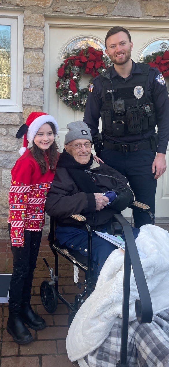 Layla Leuthy Peck, 7, and her father, Penndel Police Officer Sean Peck, congratulate Joseph Gagliardi of Newtown Township on his 100th birthday Friday. Layla brought the centenarian 100 birthday cards made by her classmates at St. Andrew School in Newtown.