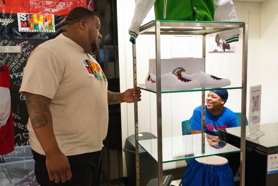 Aaron Green talks to his mentee Jesse Rollins, 14,  while working at his clothing line store called "Struggle Made Me," June 28, 2022, in Indianapolis at Circle Center Mall. Green runs a non-profit called "Struggle Made Us," which is aimed at providing mentorship to at-risk youth around Indianapolis. He is part of a large number of Black Hoosiers who are fearful of the impact new constitutional carry laws will have on gun violence in their communities.