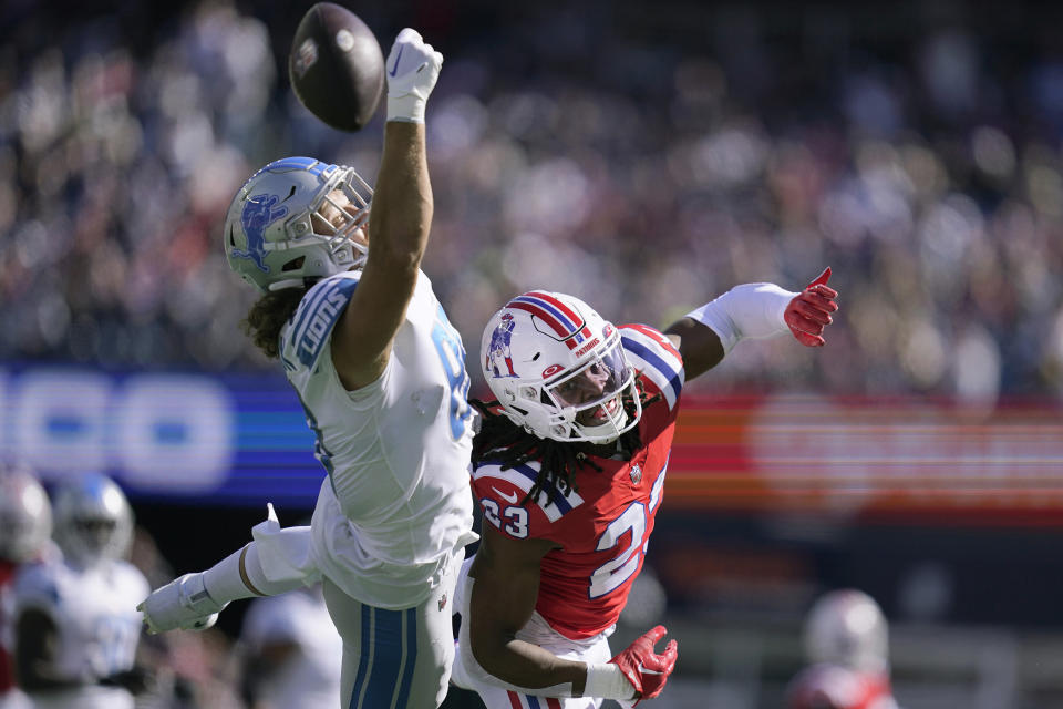 Detroit Lions tight end T.J. Hockenson, left, is unable to get a grip on the ball as New England Patriots safety Kyle Dugger, right, defends during the first half of an NFL football game, Sunday, Oct. 9, 2022, in Foxborough, Mass. (AP Photo/Charles Krupa)