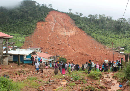 People inspect the damage after a mudslide in the mountain town of Regent, Sierra Leone August 14, 2017. REUTERS/ Ernest Henry