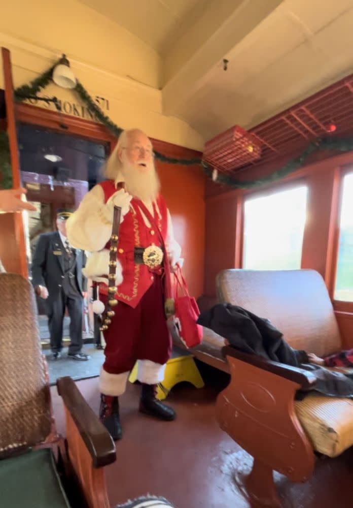 A Santa figure inside a steam train cabin